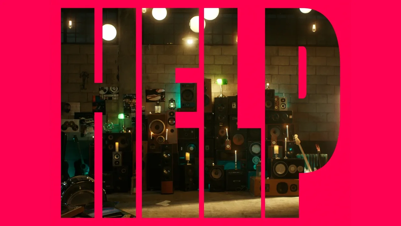 Help MV title card — bold magenta 'HELP' letterform cut over a candlelit room stacked with vintage speakers